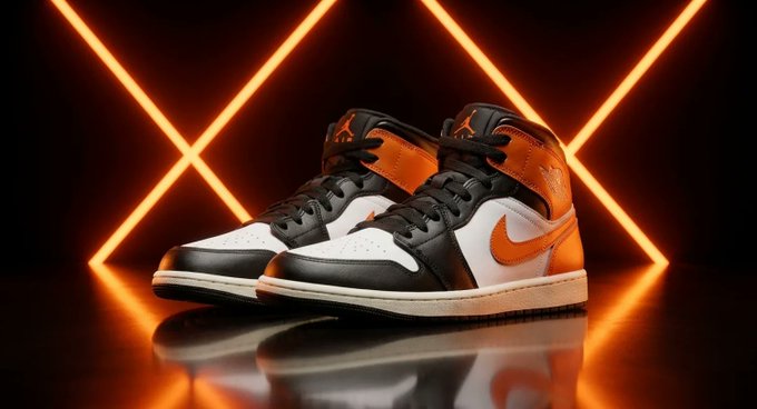 A pair of Air Jordan 1 Mid "Shattered Backboard" sneakers featuring a black, white, and orange colorway, displayed against a backdrop of glowing orange neon lights—representing the limited-edition basketball-inspired shoes that Strategy's $250 sneaker sold out immediately after launch, despite not accepting Bitcoin as payment.