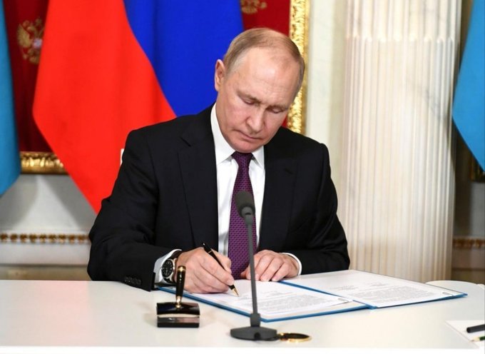 President Putin signs a new law on September 1st, allowing regulated crypto trading in Russia. This image depicts the moment of official decree, contrasting with the ongoing debate in the U.S. regarding similar regulations.