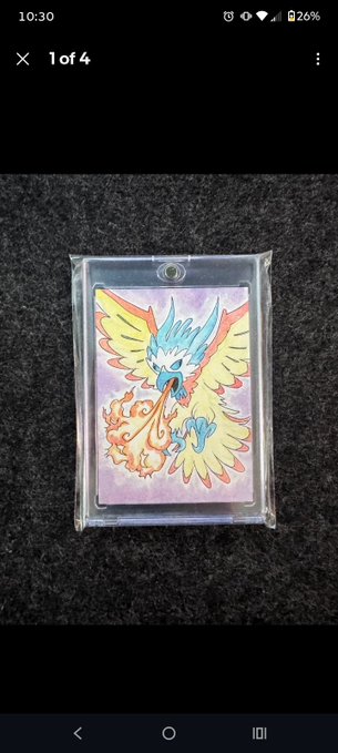 A Pokémon card featuring the legendary bird Moltres is displayed in a protective sleeve, photographed against a dark carpet background on a mobile device screen.