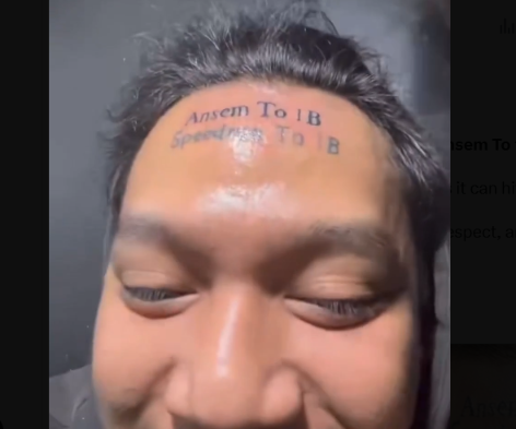 A close-up of a person's forehead with a tattoo reading 'Ansem To 1B Speedrun To B'.