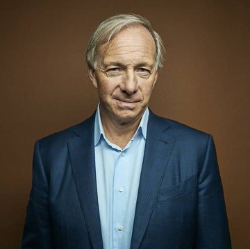 A portrait of Ray Dalio, the billionaire investor, shown in a navy blazer and light blue shirt against a brown backdrop. His image accompanies news of his recommendation for investors to diversify into gold, bonds, and Bitcoin amid concerns about government-backed money.