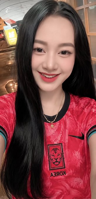 The image features a woman with long black hair wearing a red shirt, smiling at the camera. The photo has been edited to include text that reads "Mục tiêu khi build 𝕏 của mình rất đơn giản Luôn sẵn sàng kết nối, dù tài khoản của bạn lớn hay nhỏ gia nào, mang màu da nào không trên hânh". The woman's smile and the edited photo create a positive and engaging atmosphere.