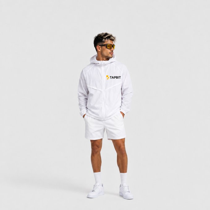 A male model wearing sunglasses stands in a white 'TAPBIT' branded hooded windbreaker, white shorts, white socks, and white sneakers against a gray background.