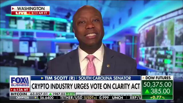 The image shows a man wearing a suit and tie sitting at a desk with a TV screen behind him, displaying news coverage of a Cryptocurrency bill being discussed by the Senate. The man appears to be a political commentator or reporter, possibly discussing the implications of the Cryptocurrency bill on the economy and its potential impact on businesses like Bitcoin.