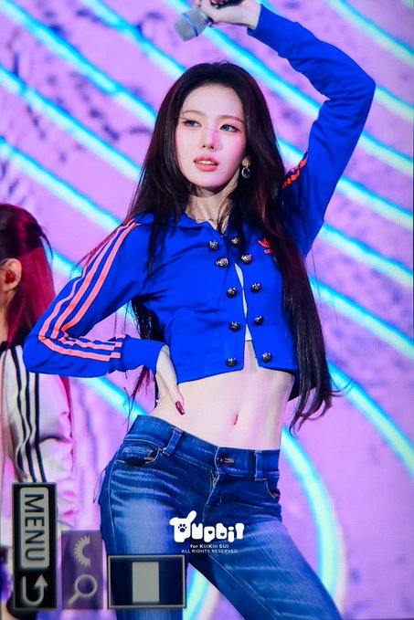 A female K-pop performer with long dark hair dances on stage wearing a blue cropped Adidas jacket and jeans, with a 'Mobil Entertainment' watermark visible.