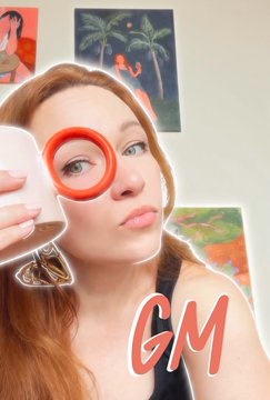 A selfie of a woman drinking from a white mug, with 'GM' written in pink text at the bottom.