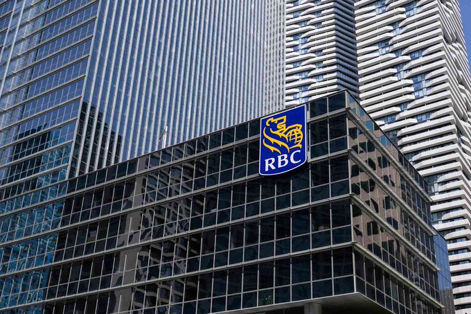 The image features a tall building with lots of windows, standing next to another skyscraper at a city intersection. In the foreground, there's a large RBC bank logo that spans across both buildings, indicating its presence as a prominent banking institution. The post accompanying the image provides some intriguing information related to RBC and XRP: "THIS IS BIG: $1,500,000,000+ banking giant Royal Bank of Canada now holds significant amounts of 𝐑𝐚𝐨𝐞𝐲𝐠𝐨𝐬. 𝐀𝐹𝐰𝐡. . 𝐂𝐨𝐝". The image suggests that RBC, a well-established financial institution with substantial holdings in digital assets like XRP, is actively involved in the cryptocurrency space and can save banks an average of 46% per payment.