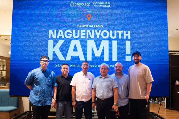 Six men pose in front of a large screen displaying 'BAGYO KA LANG, NAGUENYOUTH KAMI!' with logos for bagyo.app and BLOCKCHAIN GOOD BILLIANCE.