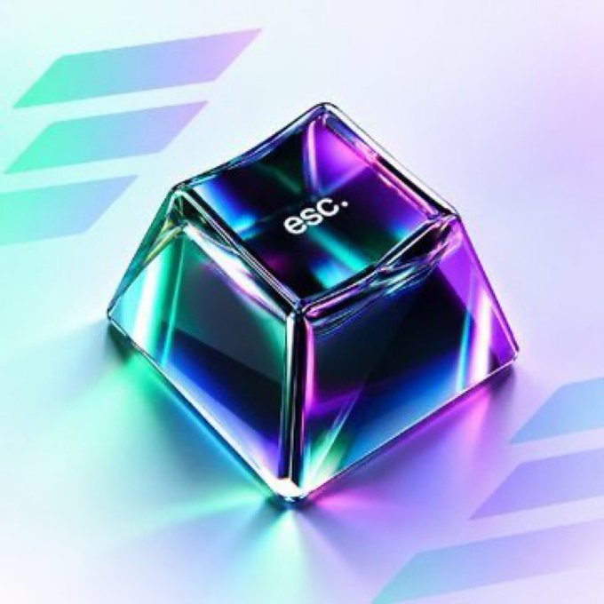 A 3D-rendered metallic crystal with the text 'esc.' sits on a surface, displaying iridescent rainbow reflections against a pastel background.