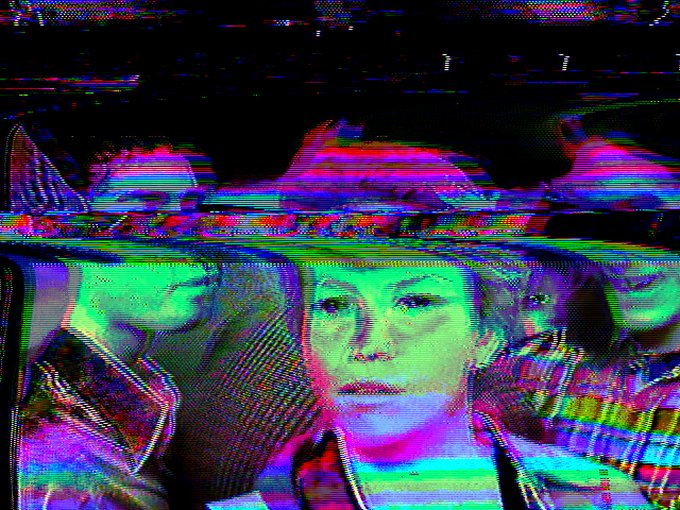 A distorted, glitch-effect image featuring repeated faces and hats in saturated green, pink, and purple hues.