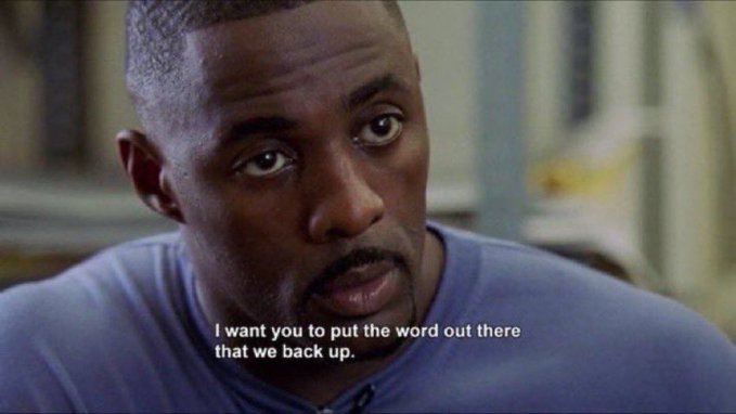 A movie still showing a man with a mustache in a blue shirt speaking, with the subtitle 'I want you to put the word out there that we back up.'