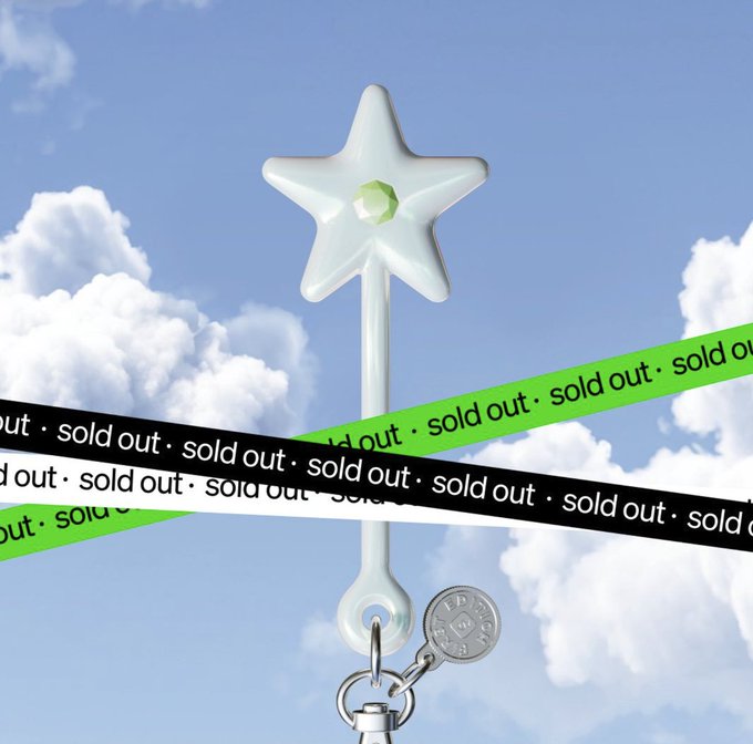The image features a white star charm attached to a keychain with a silver chain. The star charm has a green gemstone at its center, making it visually appealing. The background of the image shows a blue sky filled with clouds, creating an interesting contrast between the star charm and the sky. The post is titled "SOLD OUT - Sold Out" in black text on a white background, indicating that the charm has been sold out or is no longer available for purchase.