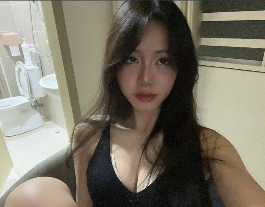 A woman with long dark hair in a black top takes a mirror selfie in a bathroom, while the caption "gm cabal" likely greets her crypto community members with a casual "good morning."