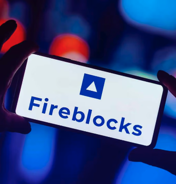 A smartphone displays the Fireblocks logo and name against a blurred blue-and-red background. The image illustrates a report that Fireblocks denied claims Visa is in late-stage talks to acquire the crypto custody firm for $2.5 billion.