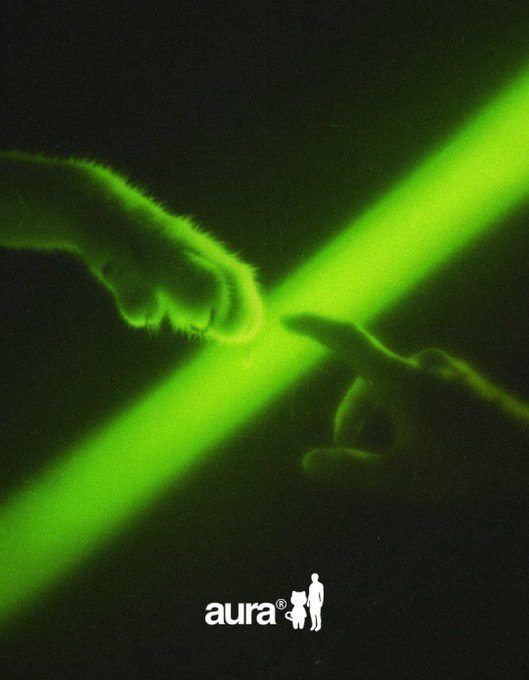 Two hands reach toward each other in a green-lit "Creation of Adam" pose, with their fingers touching at the center where a bright green aura beam crosses through, above the text "aura®" with a small silhouette icon. The image visually personifies the post's joke about "accumulating aura," suggesting that every point of connection or "aura" earned brings one closer to gaining the cherished brand logo.