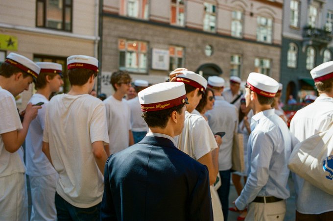 A group of students wearing graduation caps with the inscription "Støb & Brygger" are captured in this analog photograph, one of 25 in the "Northern Observations" collection. This image directly relates to the collection's theme of capturing moments around Copenhagen and Norway.