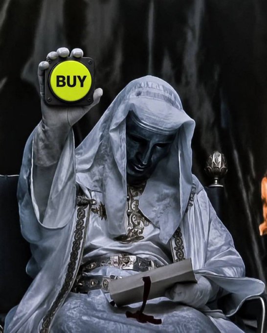 A dramatic fantasy image of a hooded figure in white robes holding a glowing yellow 'BUY' button in one hand and an open book with red ribbon in the other.