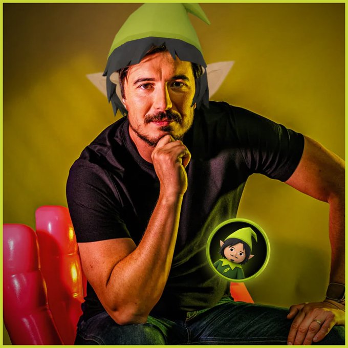 A man wearing a paper elf hat poses thoughtfully with his hand on his chin, accompanied by an inset image of a cartoon elf character, fittingly representing the "$ELVES elder" as a playful, wise leader of the crypto project.