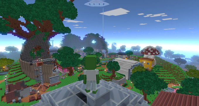 The image features a character standing atop a building with an aerial view of a town below. The character appears to be wearing a white shirt and green pants while looking out over the scene. There are several buildings visible, including one that has mushrooms growing on top. The overall setting seems to be a virtual world or game environment, as indicated by the presence of the character and the surrounding structures.
