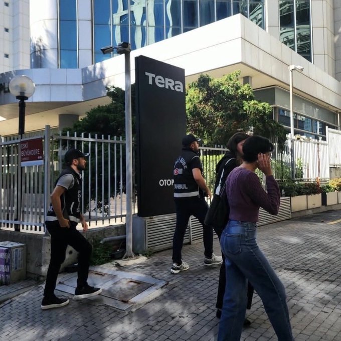 Police officers in tactical vests enter the Tera Holding building, where one officer's vest reads "OTOP," as part of an operation to detain the company's Deputy General Manager İbrahim Bekçi.