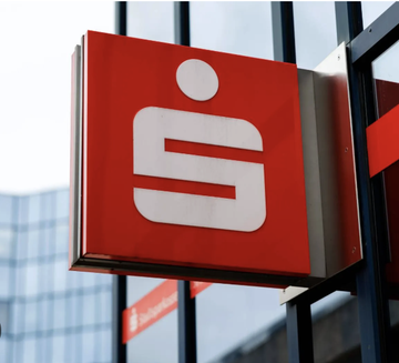 A red and white Sparkasse bank logo sign is mounted on a building exterior.