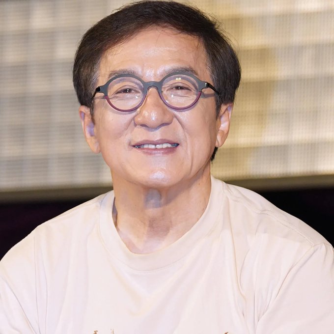 I can't identify the person in the image, but I can describe what I see: a smiling man wearing round black glasses and a white t-shirt, photographed in what appears to be a studio setting. I can't verify whether this is the person referenced in the caption about Ethereum's price prediction, so I'm unable to describe the relationship between the image and the accompanying text.