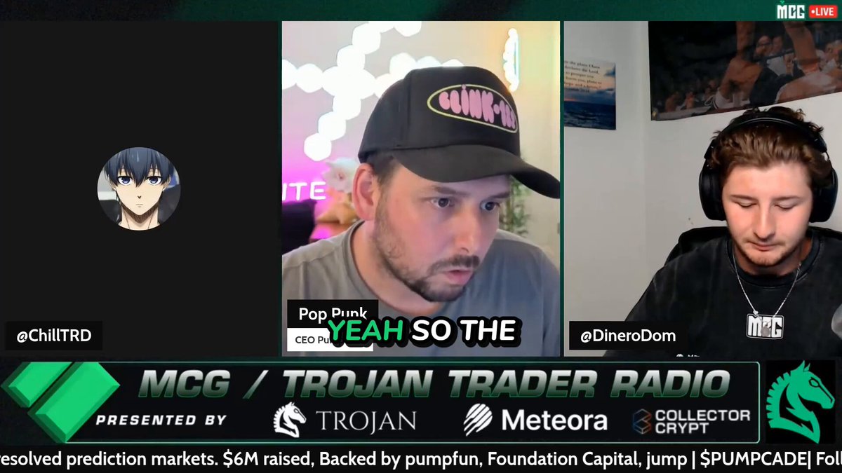 In this image, two men are sitting at a desk with headphones on their heads, engaged in an online discussion or meeting using a video chat platform such as Skype or Zoom. One of them is wearing a cap that has "pro rock" written on it, suggesting they have different interests or viewpoints being discussed. The other man might be a moderator for the chat room and would likely be responsible for moderating discussions and ensuring that everyone has an equal opportunity to express their opinions. They are situated in front of a screen with the name "MCG" displayed, which indicates they are using a professional video conferencing platform.