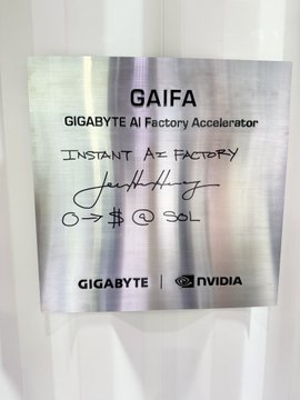 The image features a silver metal plaque with black text that reads "Instant AI Factory 0 → $0 @ SOL". The plaque has an autograph from a person named "Jack Henry" written on it, indicating that this might be a special edition item or a collector's item related to the Instant AI Factory. The plaque is displayed against a white background and is mounted on a wall.