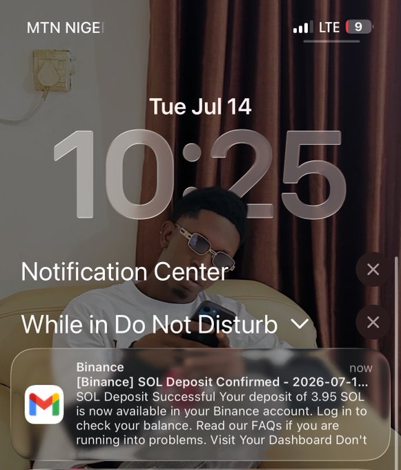 An iPhone lock screen showing the time 10:25 on Tuesday, July 14, with a Binance notification about a successful SOL deposit of 3.95 SOL, featuring a photo of a young man wearing glasses in the background.