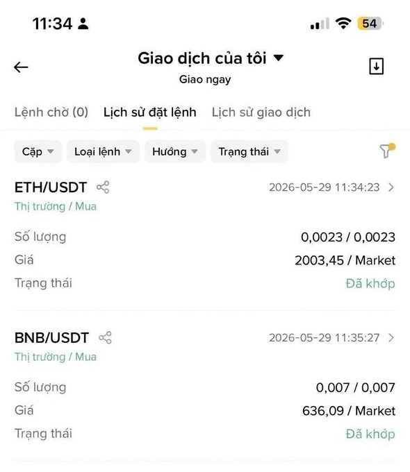 The image shows a phone screen with a list of cryptocurrency transactions displayed. The text on the screen includes information about Bitcoin (ETH), Binance Coin (BNB), and USDT, as well as the current market value for these coins. The phone is positioned in such a way that it appears to be turned off or not actively being used at the moment.
