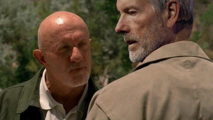 The image shows two men standing next to each other, engaged in conversation or possibly having an argument. One of them has a beard while the other one does not. The background features trees, suggesting that they are in a natural setting like a forest or park. The caption "we had a good thing" implies that there was some positive experience between these two men during their interaction.