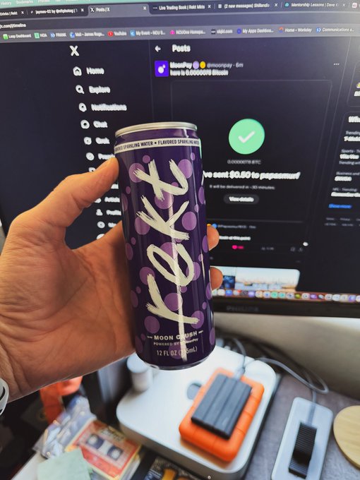 A hand holding a purple 'Moon Crush' branded beverage can in front of a computer monitor displaying a PayPal transaction confirmation page.