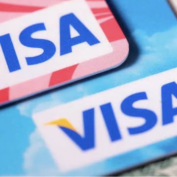 Close-up of two Visa branded cards featuring the distinctive blue "VISA" logo, visually anchoring the company's neutral, infrastructure-focused role in the stablecoin ecosystem as described in the accompanying post about Visa's support for Open USD without competing directly with Tether or Circle.