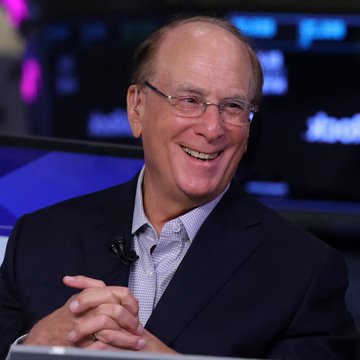 Larry Fink, CEO of BlackRock, smiles during an interview. The image complements the post about BlackRock's Bitcoin ETF accumulating an additional $80.82 million in BTC, highlighting the institutional leadership driving continued inflows into the fund.