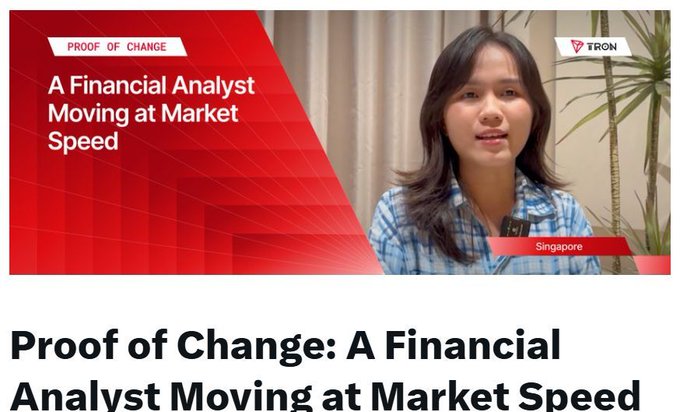 The image features a woman wearing a blue and white plaid shirt, sitting next to a potted plant while talking about financial analysis and the future of cryptocurrency. The background shows a red banner with text that reads "Proof of Change: A Financial Analysts Moving at Market Speed".