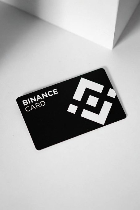 A black Binance Card with white logo and text resting on a white surface.