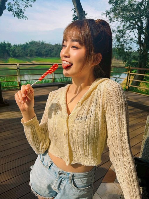 A young woman with a ponytail, wearing a cream-colored knit cardigan and denim shorts, smiles while enjoying a red spiral lollipop outdoors on a wooden deck with greenery in the background.

The image has no direct relation to the post's content about Ethereum ETF inflows; it appears to be a generic lifestyle/portrait photo likely used as a visually appealing thumbnail unrelated to the cryptocurrency discussion.