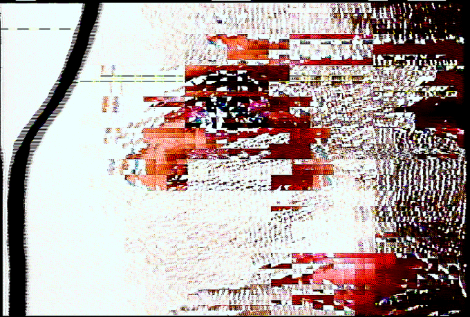 A heavily glitched or corrupted image showing fragmented red, white, and black pixels with a thick, wavy black line on the left side.