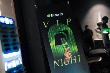A Bitunix-branded sign reading "VIP NIGHT" glows green at what appears to be an upscale venue, capturing the atmosphere of the crypto exchange's exclusive VIP event in Asia as referenced in the promotional post.