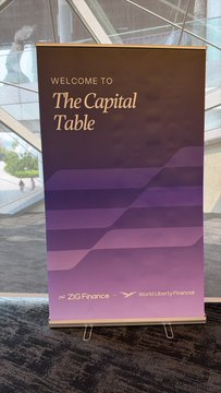 A welcome sign on a display easel reads 'WELCOME TO The Capital Table' in purple gradient styling, co-hosted by ZIG Finance and daos.li/berryfinance, set in a modern building lobby.