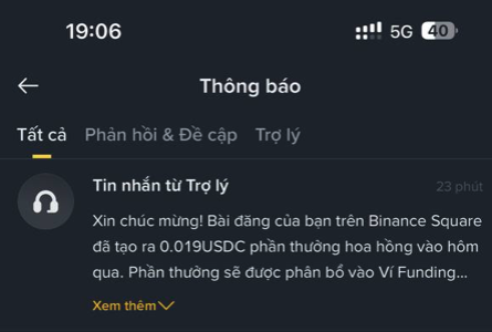 A smartphone screenshot shows a Binance notification in Vietnamese, with text reading 'Tin nhắn từ Trợ lý' and 'Xin chúc mừng! Bài đăng của bạn trên Binance Square đã tạo ra 0.019USDC phần thưởng hoa hồng vào hôm qua. Phần thưởng sẽ được phân bổ vào Ví Funding...'