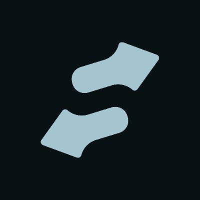 Two light gray, stylized abstract shapes resembling an exchange or swap symbol are displayed on a dark gray background, suggesting a meme coin or token swap interface related to StonkFun's platform milestone.