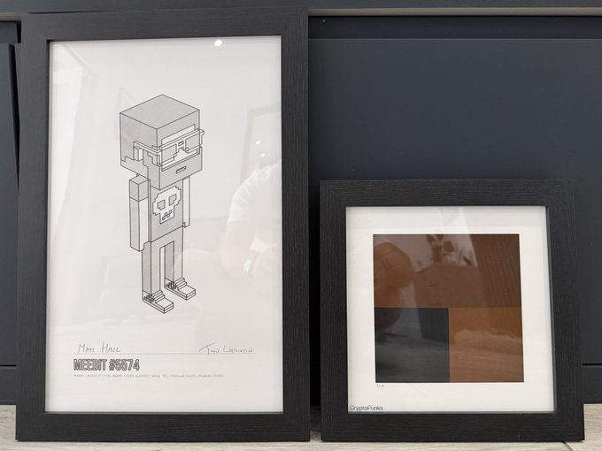 Two framed CryptoPunks prints displayed side by side: a "Meebit #6674" illustration on the left (signed "Mom Hair") and a smaller "CryptoPunks" print on the right, presented as rare grail collectibles.