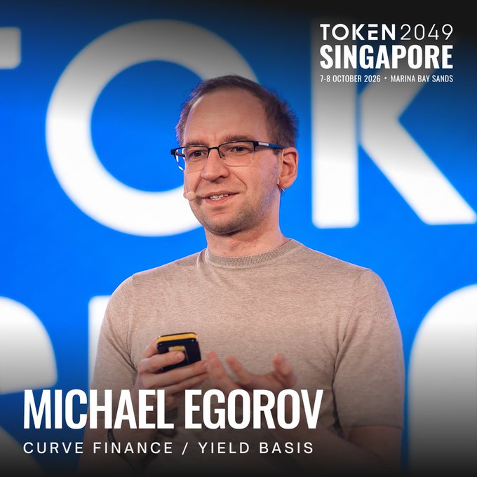 Michael Egorov, founder of Curve Finance and Yield Basis, is shown speaking on stage at TOKEN2049 Singapore (7-8 October 2026, Marina Bay Sands), aligning with his return to the conference as a featured speaker discussing his latest crypto volatility-to-yield project.