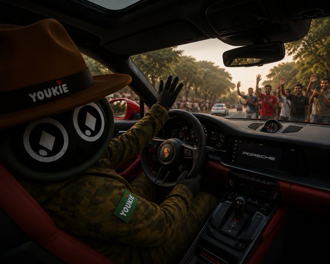 The image features a person wearing a hat with "Youkie" written on it, sitting inside a car. The car has a red interior, and there are several people visible outside of the vehicle. A caption related to the image reads: "I preach taking profits in crypto but held a 4x bag back to almost zero while scrolling @RallyOnChain and pretending patience was a strategy."
