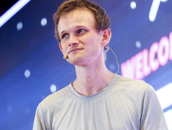 Vitalik Buterin stands in front of a backdrop displaying the word "WELCOME," wearing a headset microphone. The image accompanies news about his updated Ethereum roadmap through 2029, emphasizing planned upgrades centered on privacy and quantum resistance.