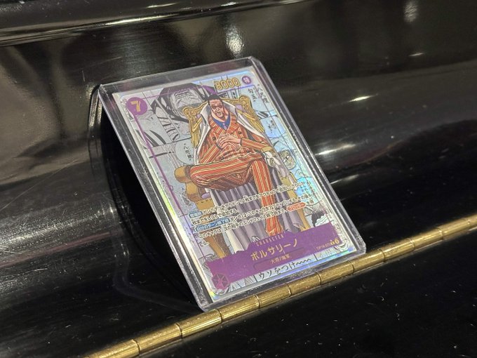 A holographic One Piece trading card featuring the character Porchemy (ポルサリーノ/サンジ) in a protective sleeve displayed on a dark surface.