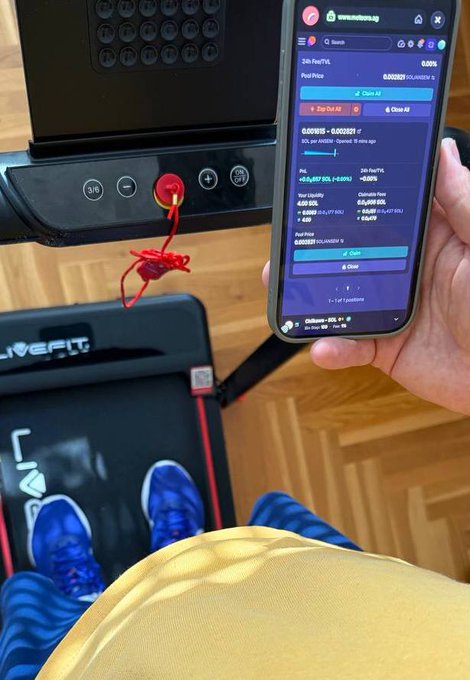 A first-person view of someone on a Livefit treadmill wearing blue shoes, holding a phone displaying a memecoin trading interface on nexusdex.io while a red string hangs from the treadmill's emergency stop button.