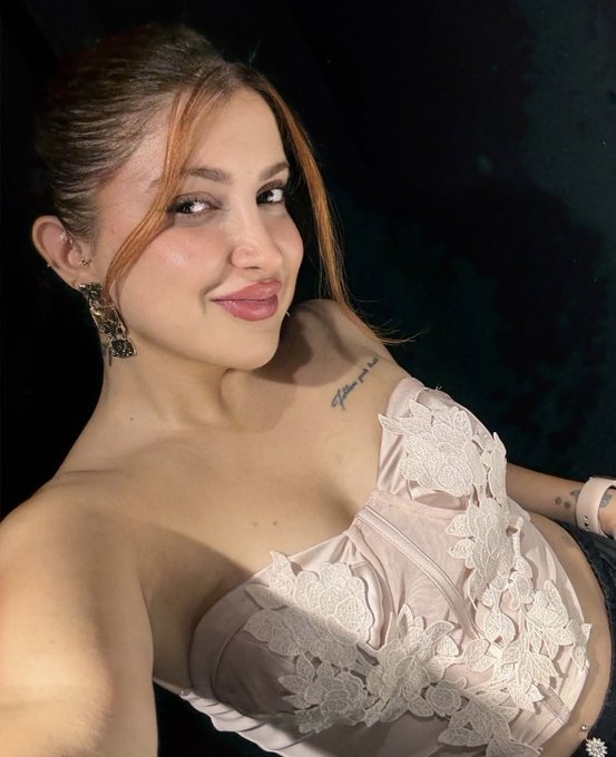 A woman with long brown hair poses in a strapless blush-colored lace dress against a dark background, smiling subtly at the camera. The glamorous, confident portrait reflects the post's message of embracing a vibrant life beyond the intensity of the Web3/crypto world.