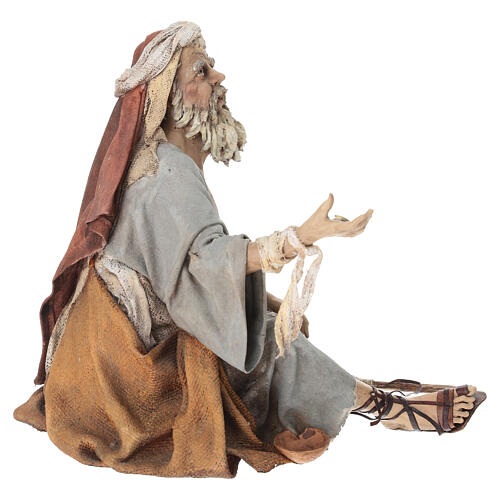 A figurine of a kneeling, bearded man in robes with his hands extended outward and wrapped in torn bandages, evoking a religious or biblical scene. 

The image likely symbolizes a moment of supplication or pleading — fitting the post's reference to "$ANSEM" being in its "current phase," possibly representing the market's humble, asking posture toward the memecoin.